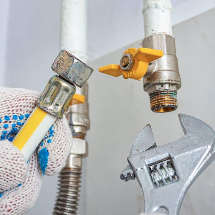 man holding hose at top of water heater