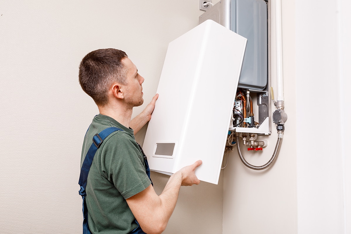 man holding hose at top of water heater