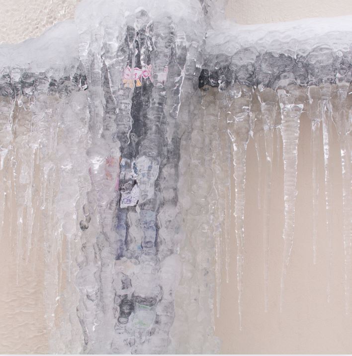 man holding hose at top of water heater